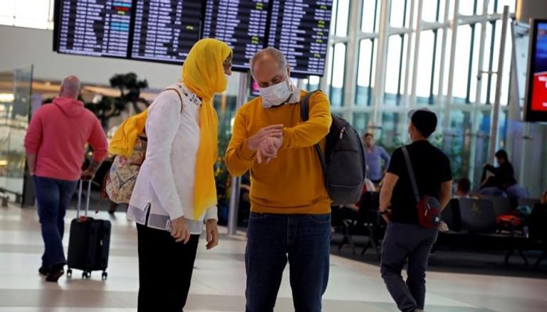 رجل وامرأة يرتديان أقنعة واقية في مطار إسطنبول
