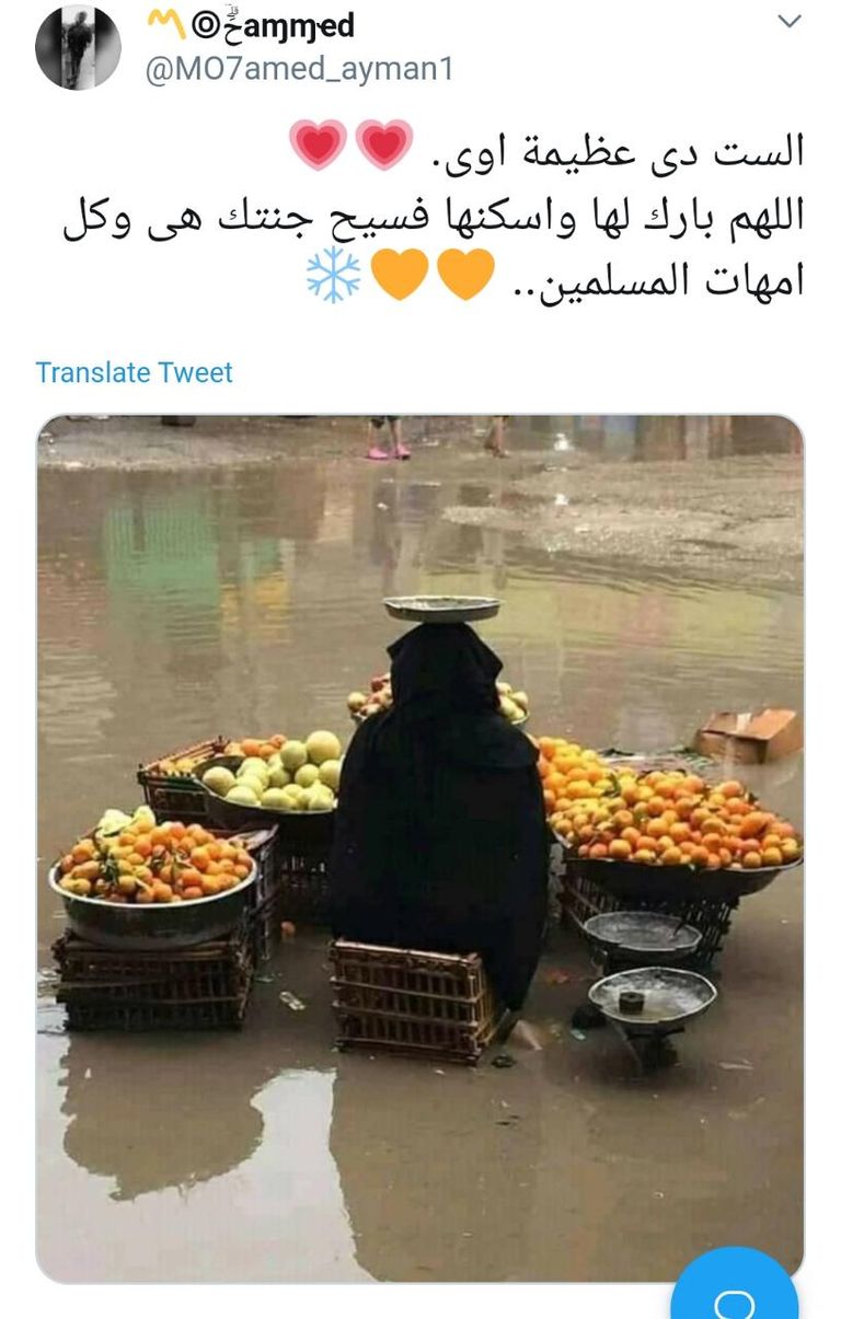 مسنة تبيع الفاكهة وسط هطول الأمطار بمصر