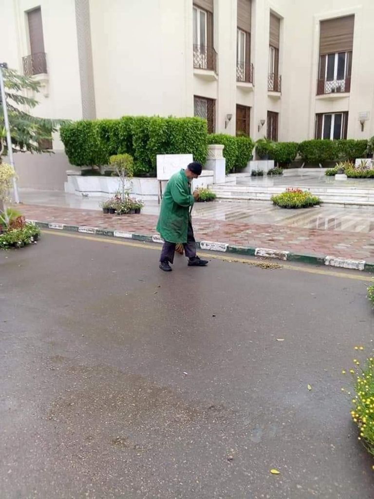 مسنة تبيع الفاكهة وسط هطول الأمطار بمصر