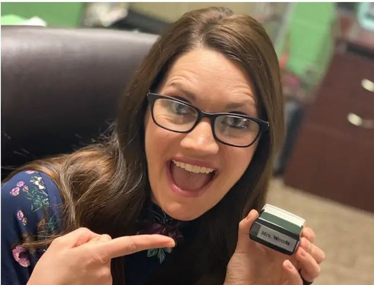 معلمة تضع ختمها على أيدي الطلاب لتشجيعهم على غسلها