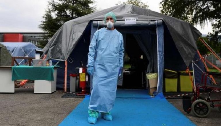 طبيب يقف أمام خيمة الفرز أقيمت أمام مستشفى إيطالي