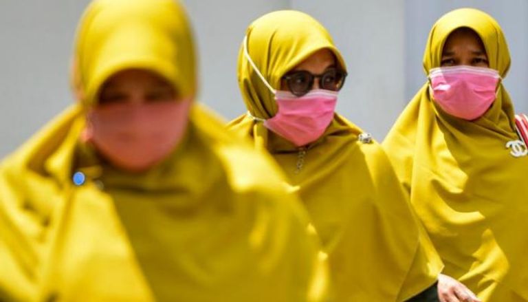 سيدات يرتدين كمامات في شوارع إندونيسيا خوفا من كورونا
