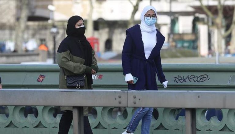 شابتان ترتديان كمامتين واقيتين في قطر - أرشيفية
