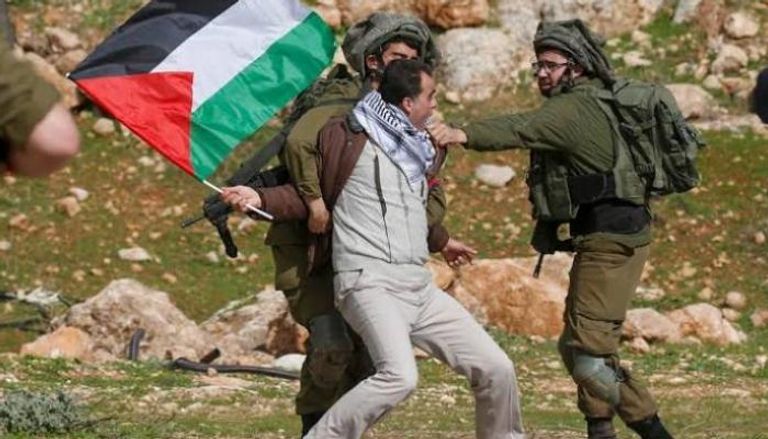 فلسطيني بين أيدي قوات الاحتلال الإسرائيلي