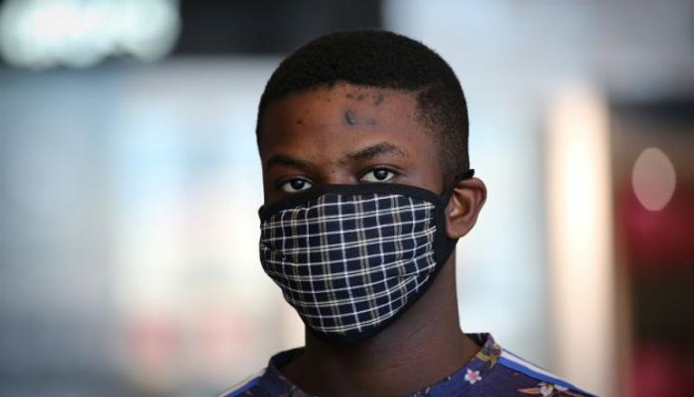 شاب يرتدي قناع وجه كإجراء وقائي ضد فيروس كورونا