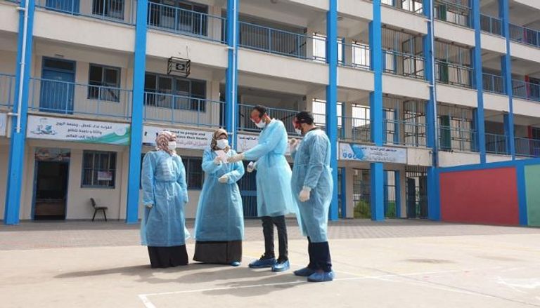 أطباء يرتدون أقنعة وجه في فناء إحدى مدارس غزة