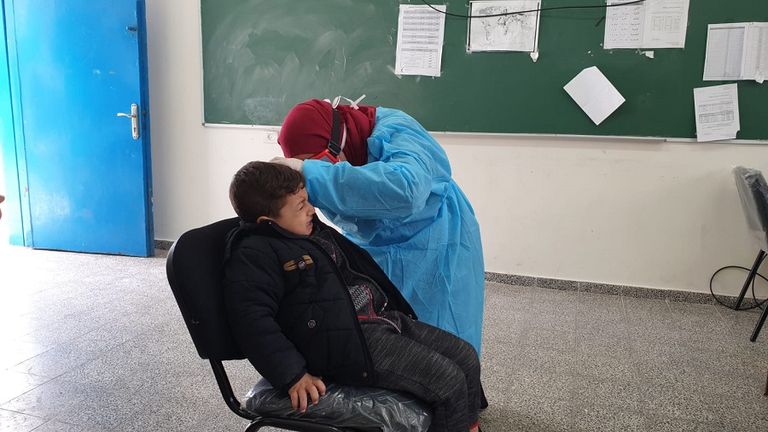 أطباء يرتدون أقنعة وجه في فناء إحدى مدارس غزة