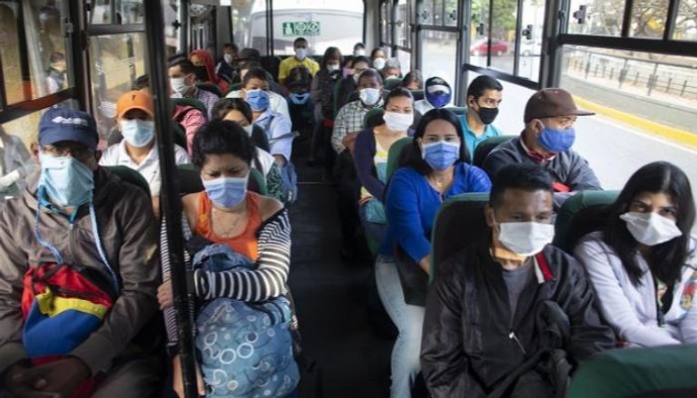 أشخاص يرتدون أقنعة في حافلة بكاراكاس في فنزويلا