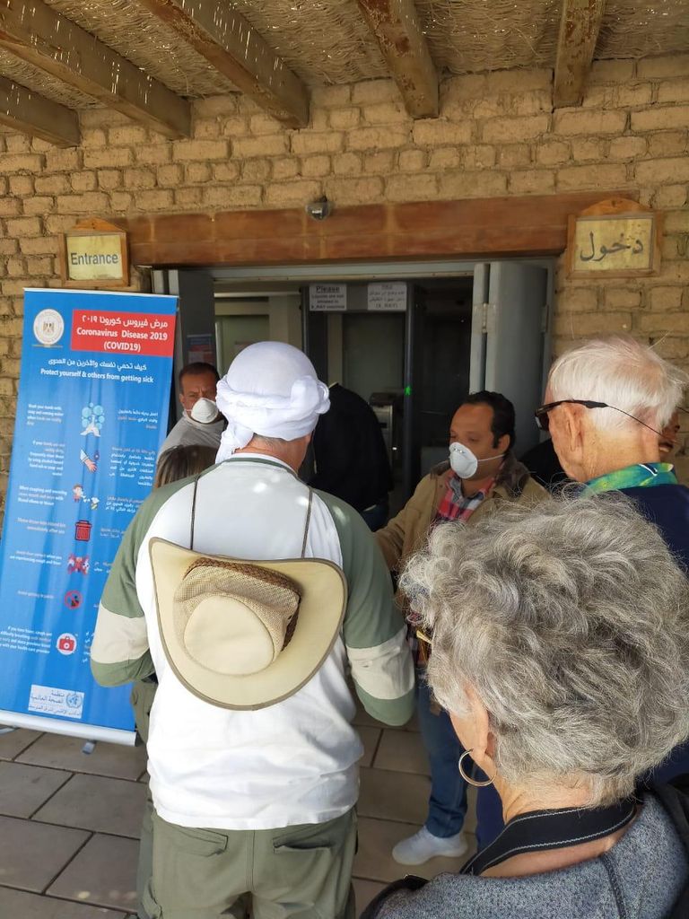 سائح أمام لافتة توعية بمخاطر "كورونا" داخل المتحف المصري