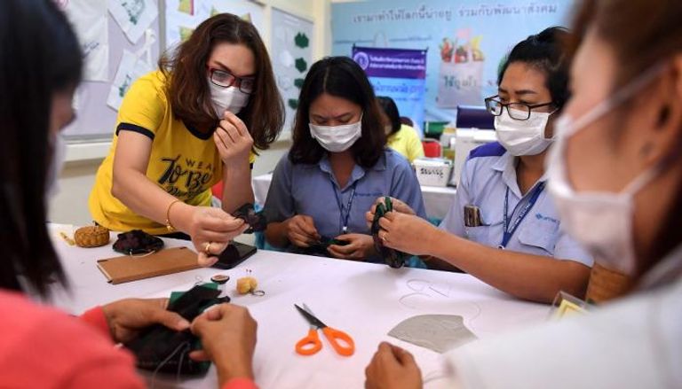تايلانديات يتعلمن في ورشة كيفية صناعة الكمامات الواقية