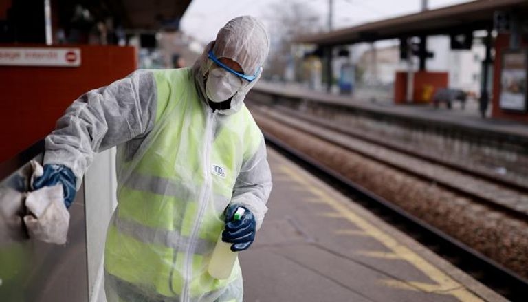 عامل ينظف محطة قطار في فرنسا بمطهر لإبطاء معدل الإصابة بكورونا