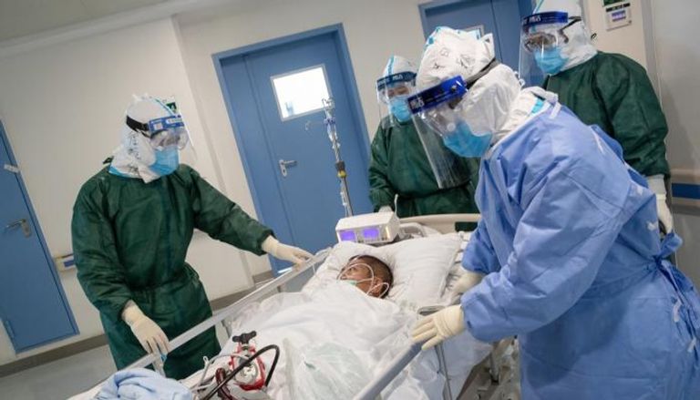 مريض بكورونا يرافقه أطباء العزل بأحد المستشفيات