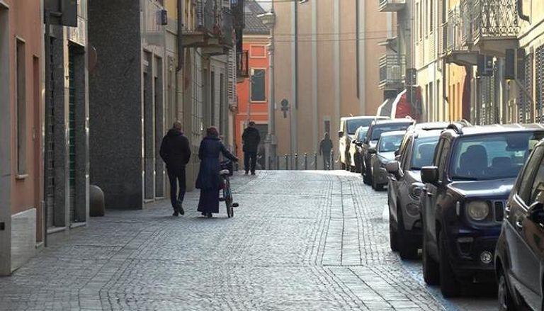 أشخاص تسير في أحد شوارع إيطاليا الفارغة إثر مخاوف كورونا - رويترز