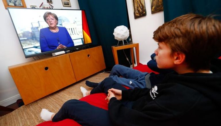 ألمان يتابعون كلمة لميركل عبر شاشات التلفزيون من المنازل
