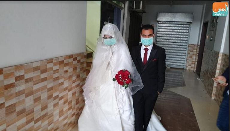 عروسان يرتديان الأقنعة الطبية في قطاع غزة للوقاية من كورونا