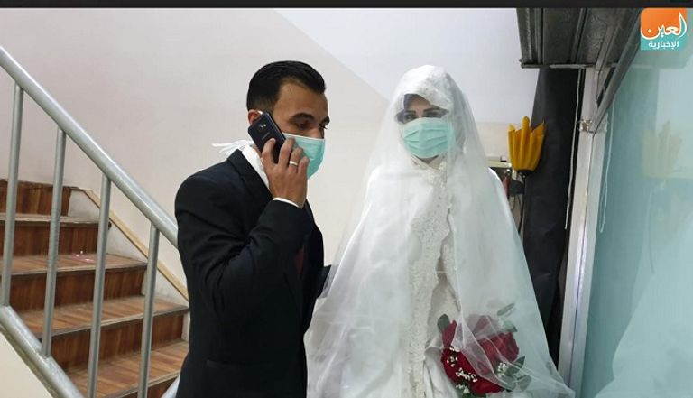 شاهين العريس وعروسته يرتديان الكمامة خلال حفل الزواج بقطاع فزة للوقاية من فيروس كورونا المستجد عروسان يرتديان الأقنعة الطبية في قطاع غزة للوقاية من كورونا