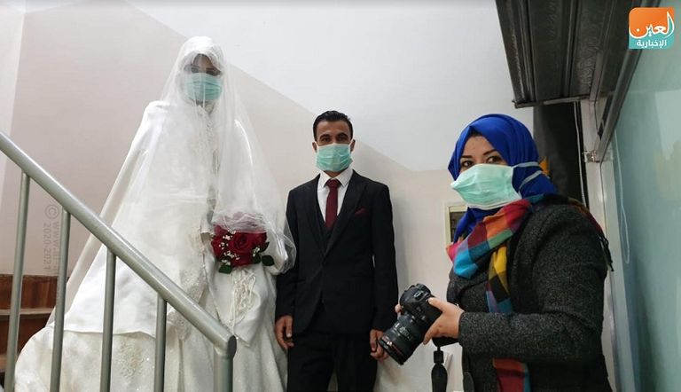 عروسان في قطاع غزة يحتفلان بزفافهما بالكمامة للوقاية من فيروس كورونا الجديد عروسان يرتديان الأقنعة الطبية في قطاع غزة للوقاية من كورونا