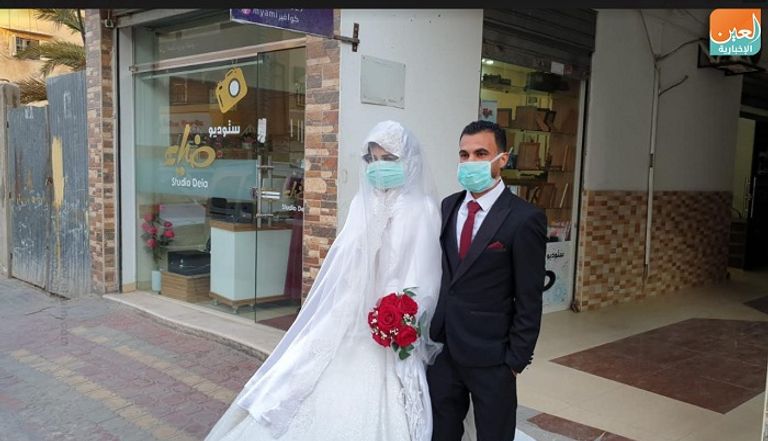 عروسان في قطاع غزة يحتفلان بزفافهما بالكمامة للوقاية من فيروس كورونا الجديد عروسان يرتديان الأقنعة الطبية في قطاع غزة للوقاية من كورونا