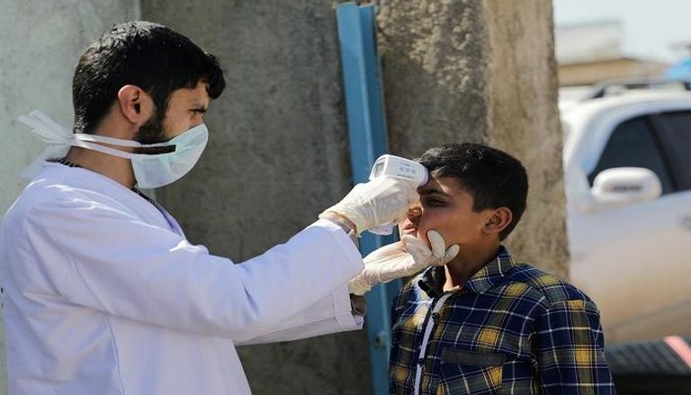 طبيب سوري يجري اختبارا لأحد النازحين