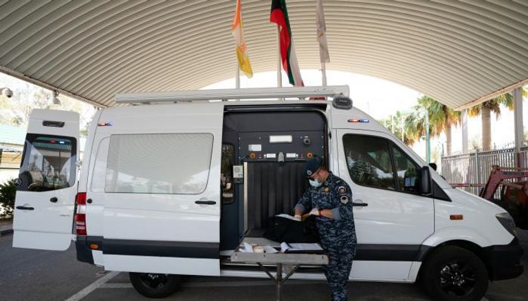 ضابط كويتي يفحص حقيبة في مركز للحجر الصحي في خيران
