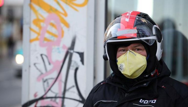 رجل يرتدي قناع وجه للوقاية من فيروس كورونا في بريطانيا