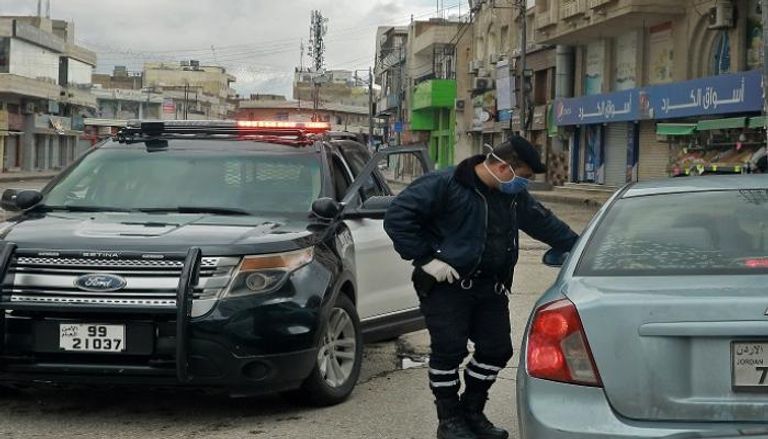 الشرطة الأردنية خلال توقيف المخالفين لحظر التجوال - أ.ف.ب