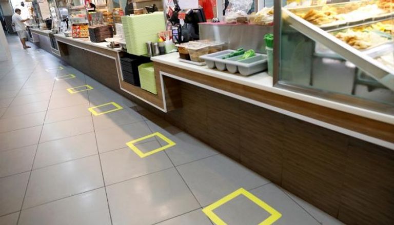 مركز لبيع الطعام في سنغافورة يحدد أماكن وقوف للزبائن في إطار المسافة الآمنة لاحتواء فيروس كورونا