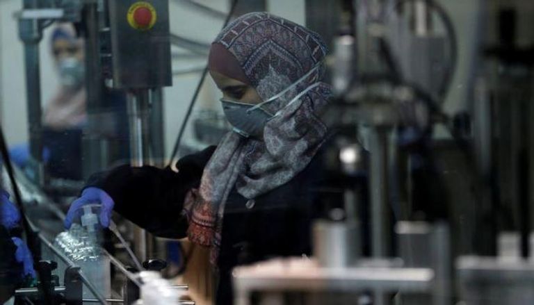 فلسطينية ترتدي كمامة خلال متابعة عملها
