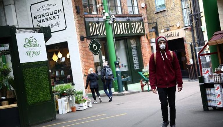 بريطاني يرتدي الكمامة في أحد شوارع لندن
