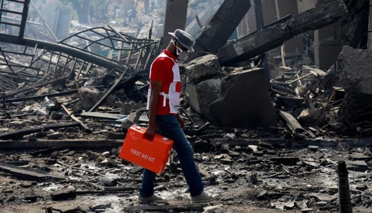 مسعف يرتدي قناعا خشية كورونا ويمر أمام موقع انفجار خط أنابيب بنيجيريا