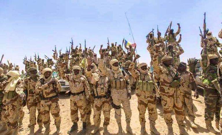 جنود من الجيش التشادي مسعف يرتدي قناعا خشية كورونا ويمر أمام موقع انفجار خط أنابيب بنيجيريا