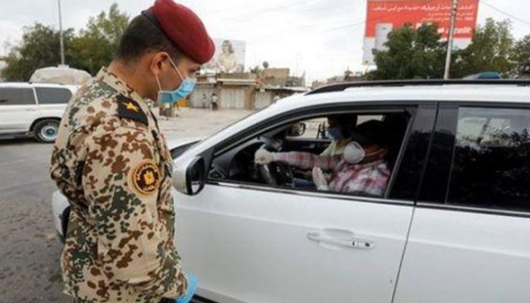 ضابط بالجيش العراقي يرتدي قناعا خلال عمله خشية كورونا  