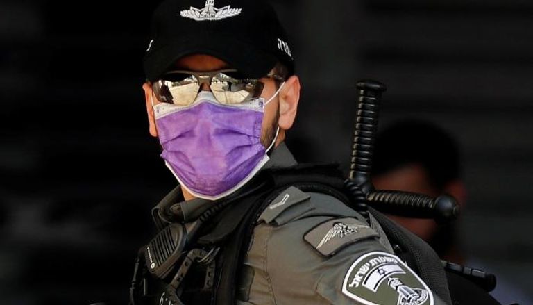 شرطي إسرائيلي يرتدي كمامة طبية للوقاية من فيروس كورونا