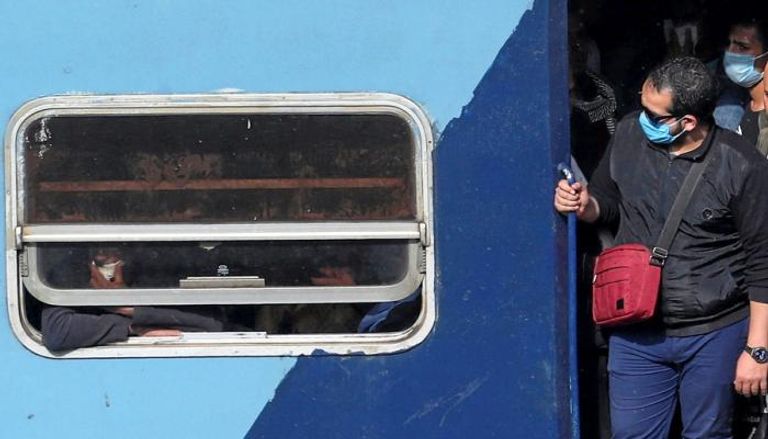 ركاب قطار يرتدون كمامات طبية للوقاية من فيروس كورونا في مصر