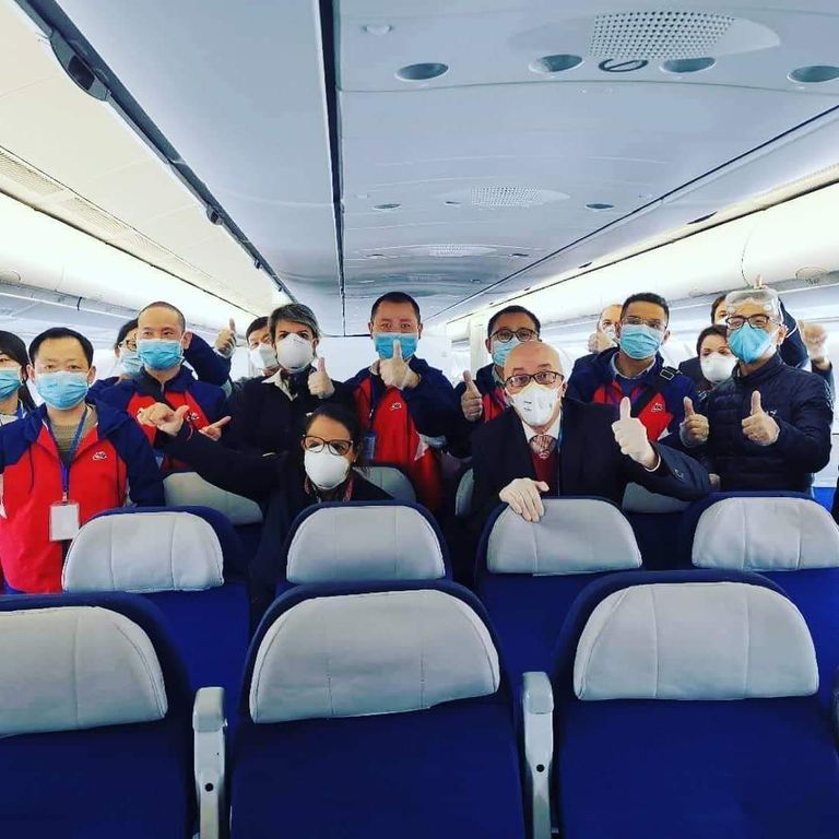 الفريق الطبي الصيني الذي وصل إلى الجزائر اثنان من الطابق الطبي يرتديان الكمامات أمام مستشفى بالجزائر