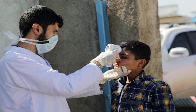 طبيب سوري يجري اختبارا لأحد النازحين