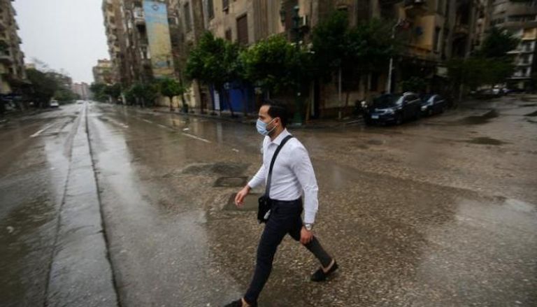 شاب مصري يرتدي الكمامة في أحد شوارع القاهرة