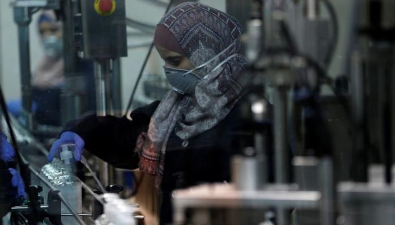 امرأة فلسطينية تعمل في مصنع مطهرات في الخليل
