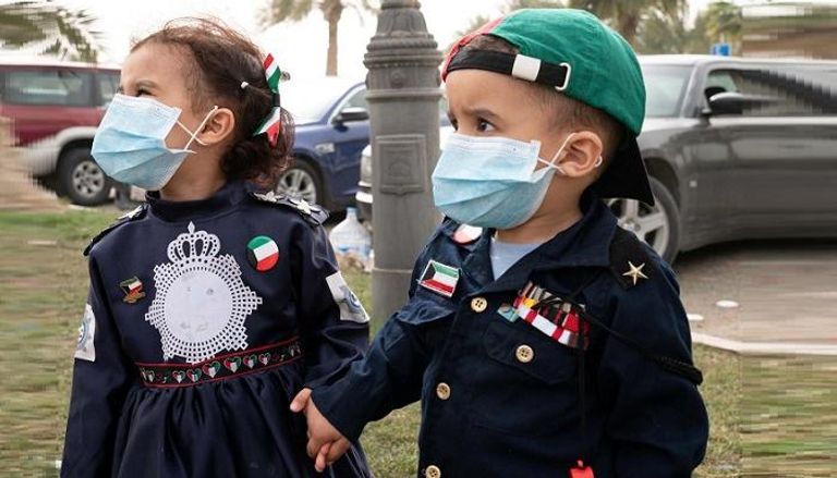 طفلان يرتديان الكمامات في الكويت