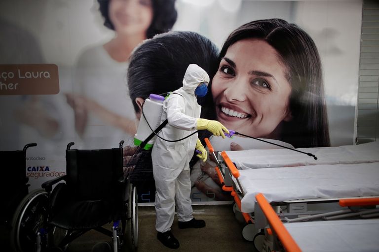 عامل يرتدي بدلة واقية ويرش مطهرات كإجراء احترازي لمنع تفشي كورونا