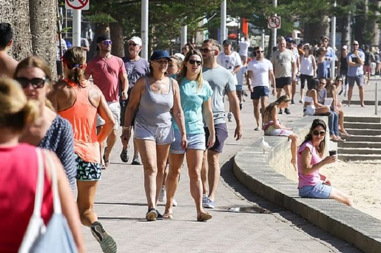 صورة لأناس يسيرون قرب شاطئ مانلي قبل العزل الذاتي ضابط يطلب من سيدة الرحيل رغم جلوسها بمفردها - ديلي ميل