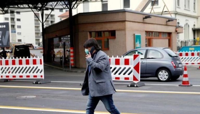 رجل يرتدي كمامة وقاية في أحد شوارع سويسرا