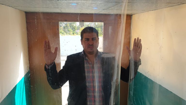 شاب يقف داخل ممر التعقيم