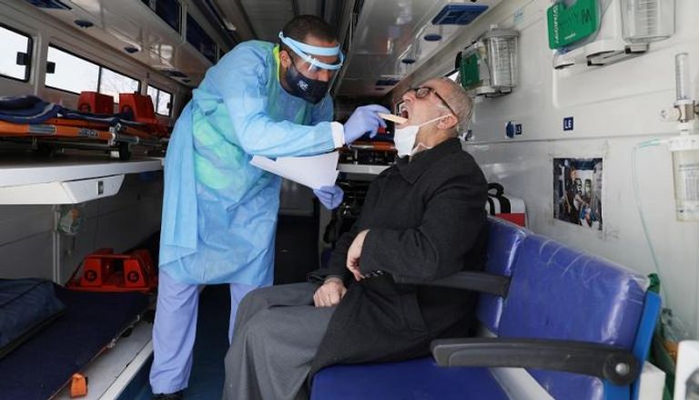 طبيب يفحص رجلا أردنيا في عيادة طبية متنقلة بالأردن