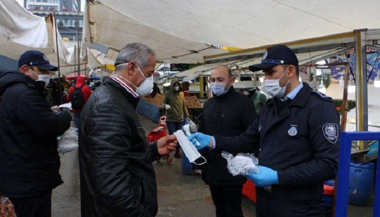 عناصر من بلدية إسطنبول يوزعون الأقنعة على الأتراك للوقاية من كورونا
