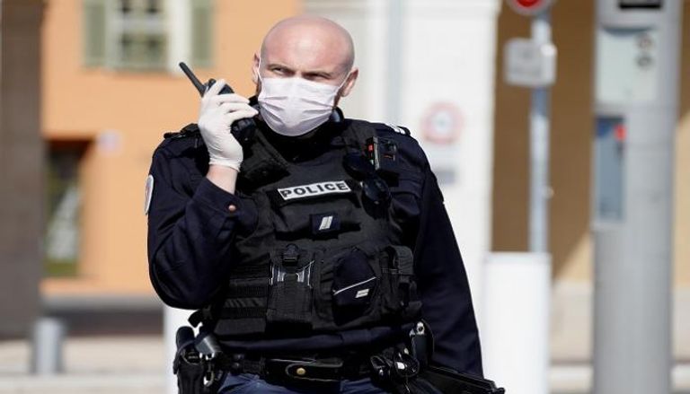 شرطي فرنسي يرتدي كمامة للوقاية من كورونا - رويترز 