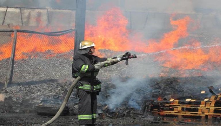أحد عناصر قوات الدفاع المدني يحاول إطفاء الحريق