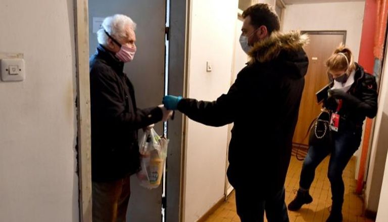 متطوع يسلم حصة غذائية لأحد المسنين في ساراييفو