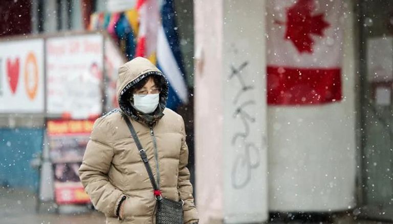 سيدة تسير في أحد شوارع كندا