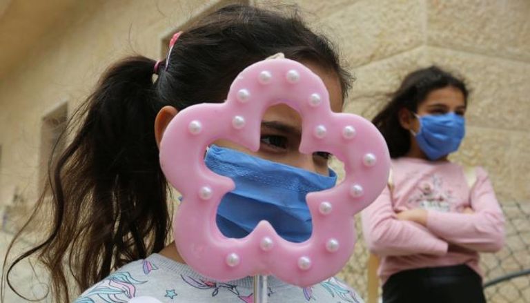 طفلتان ترتديان كمامتين للوقاية من فيروس كورونا في لبنان